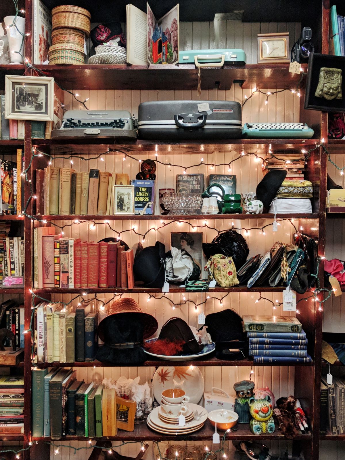 Finders Keepers antique store in Lee, MA that's decorated with string lights and full of books, china, typewriters, and hats