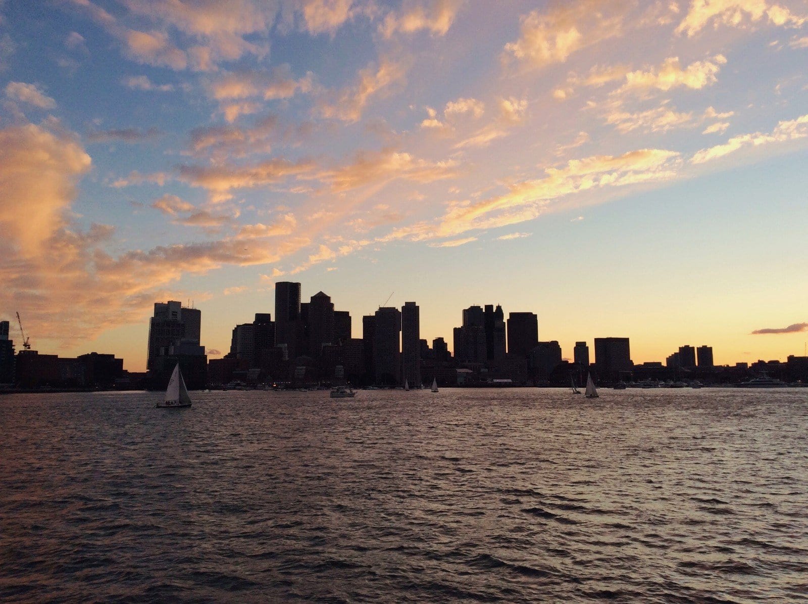 silhouette of the Boston skyline at sunset, photo by Roaming Boston