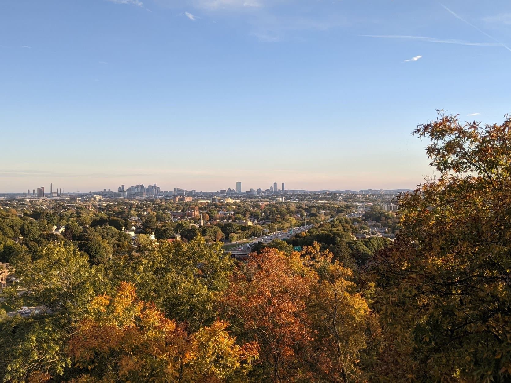The view of the city skyline at Wright's Tower at Middlesex Fells during the golden hour in the fall