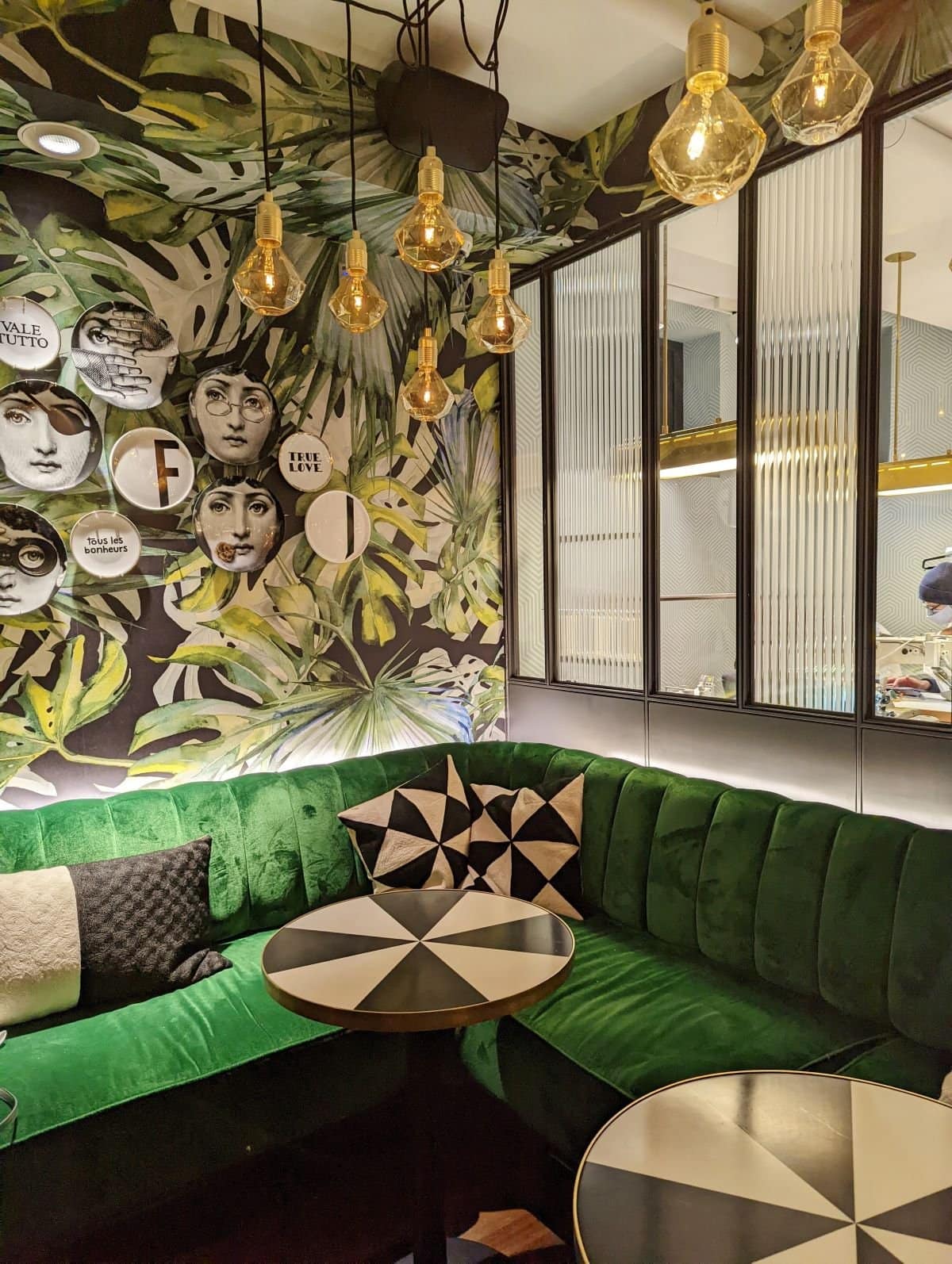 Cafe Susu seating with plush green couch and decorative wallpaper