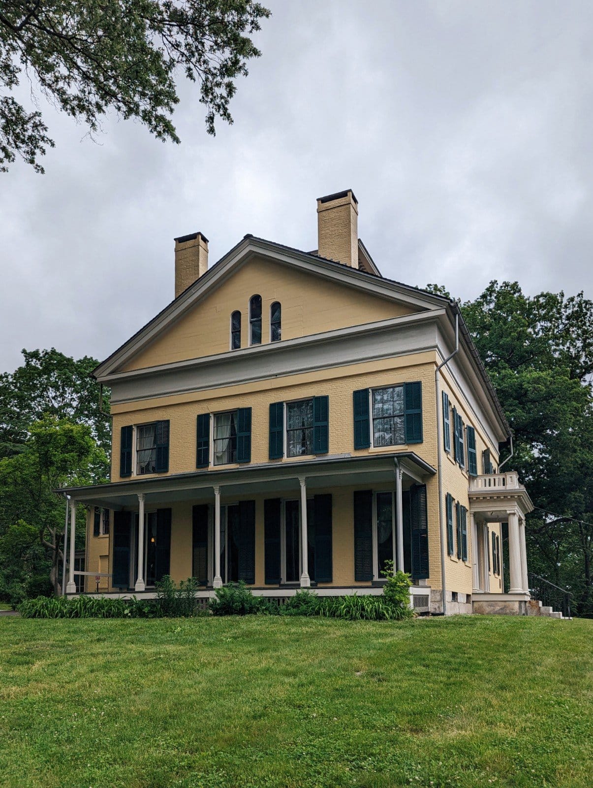 Exterior of the Emily Dickinson Museum - a yellow house with dark shutters