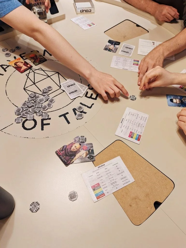 People playing the game Coup on a large table
